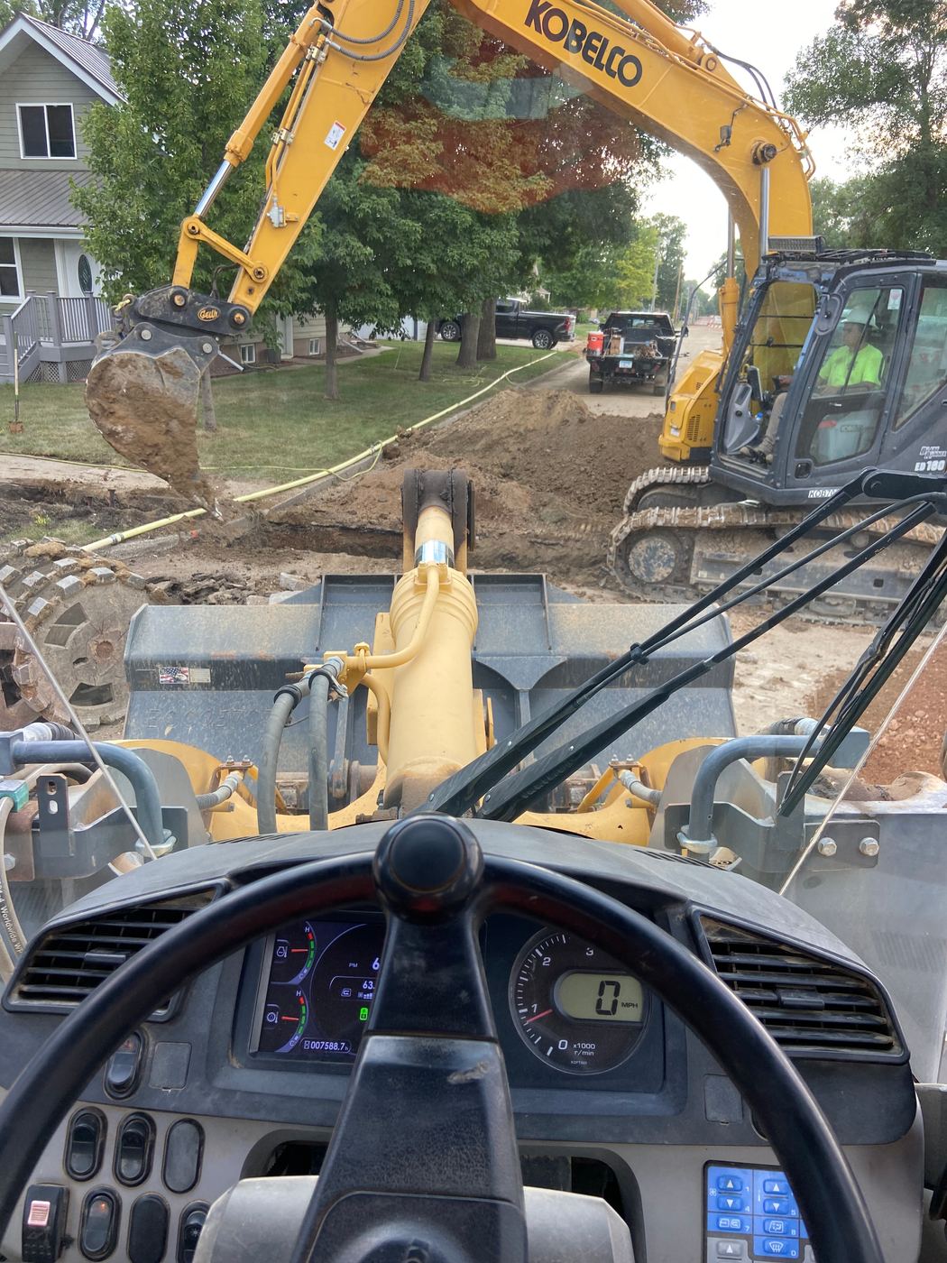 Excavator working a residential street water service replacement