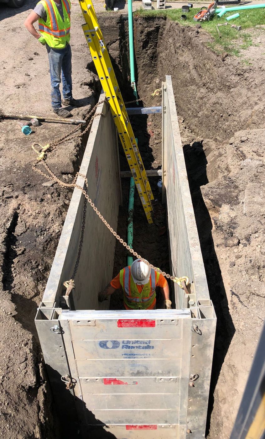 Crew member working inside a shored trench