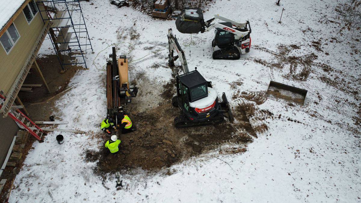 Winter water service installation with compact excavator